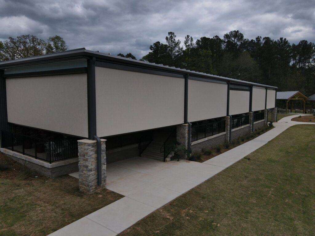Exterior roller shades providing comfortable shade in outdoor commercial areas.